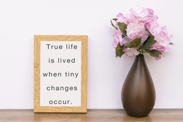 True life is lived when tiny changes occur - Inspiration quotes on wooden frame.