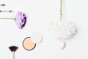 Flat lay frame makeup products and fresh flowers