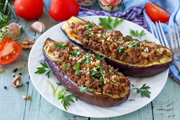 Healthy dinner. Snack. Stuffed with minced meat and vegetables eggplant on wooden table.