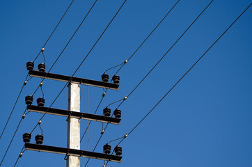 electric wires on a pole against a blue sky