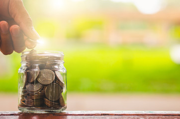 businessman putting coin stacking and money in to glass jar count the money for saving concept. budgeting for investment startup business.