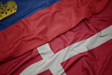 Fototapeta premium waving colorful flag of denmark and national flag of liechtenstein.