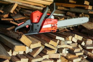 chainsaw is against the background of firewood