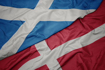 waving colorful flag of denmark and national flag of scotland.