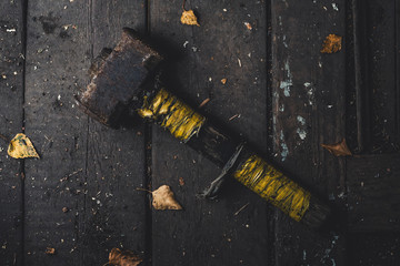 old rusty sledgehammer on a wooden background.