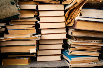 a stack of old shabby books lies on an old wooden table