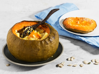 Baked pumpkin with porridge. Pumpkin is filled with cereals and milk. Organic food. Milk, corn grits, raisins, seeds. Natural products.
