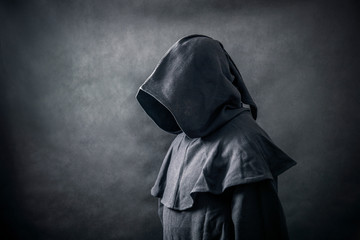 Fototapeta na wymiar Scary figure in hooded cloak 