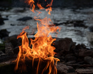 burning fire on a stone in the middle of the river