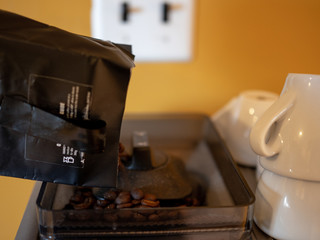 pouring coffee beans in the coffee machine
