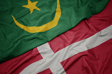 waving colorful flag of denmark and national flag of mauritania.