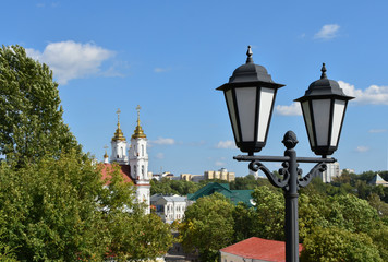 Fototapeta na wymiar Urban landscape. Lantern and view of the Church in Vitebsk, Belarus. Selective focus