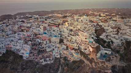 Fototapeta na wymiar Aerial drone photo of world famous beautiful sunset at traditional and picturesque village of Oia with golden colours, Santorini island, Cyclades, Greece