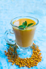 A glass of fresh vitamin drink from sea buckthorn berries. Close-up.