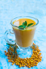 A glass of fresh vitamin drink from sea buckthorn berries. Close-up.