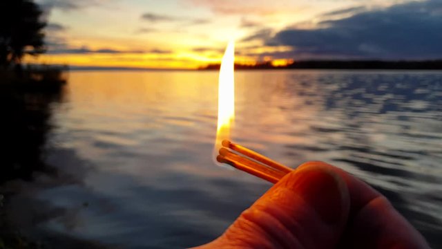 Survival in the forest. Burning match. Making a bonfire in nature.