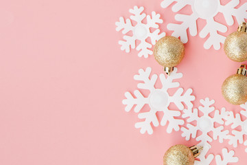 Christmas gift in women's hands and notebook on a pink background, a view from above