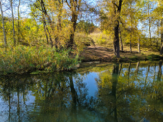 Fototapeta na wymiar autumn landscape with a river. reflection of trees in the water.