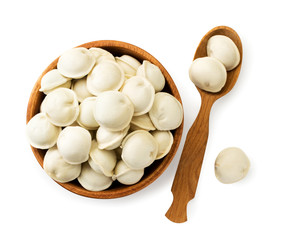 Dumplings in a wooden plate with a wooden spoon on a white. The view of the top.
