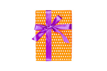 Christmas or other holiday handmade present in orange paper with purple ribbon. Isolated on white background, top view. thanksgiving Gift box concept