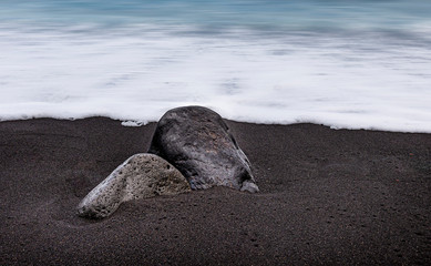 Obraz premium Big couple of rocks on the sand at the beach