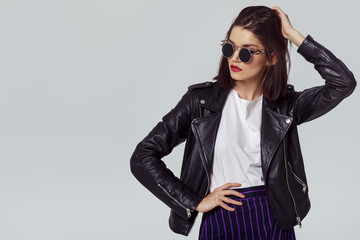 Fashion portrait of a young woman in leather jacket. - obrazy, fototapety, plakaty