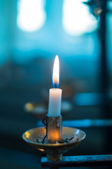 Candle in the dark bluish light.