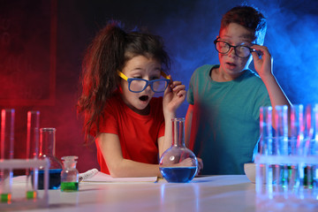 Children doing chemical research in laboratory. Dangerous experiment