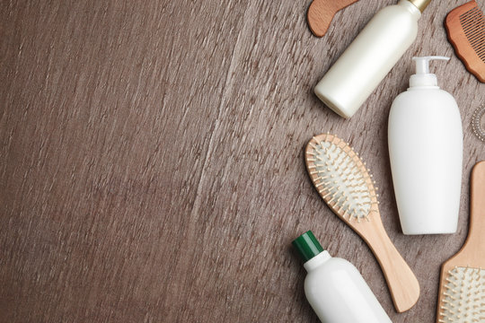 Flat lay composition with hair cosmetic products and tools on brown background. Space for text