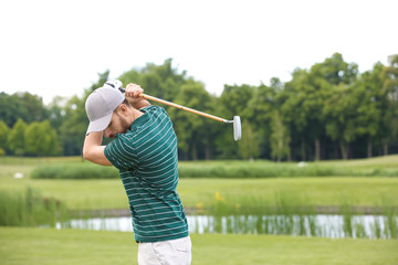 Man playing golf on green course. Sport and leisure