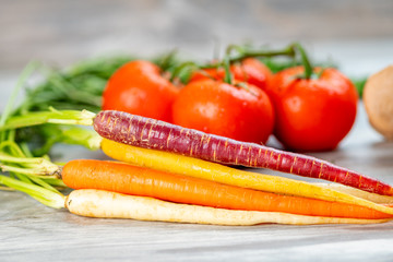 Close up of carrots with tomatoes in the background