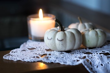 autumn and winter table decoration with candle and white baby boo pumpkins