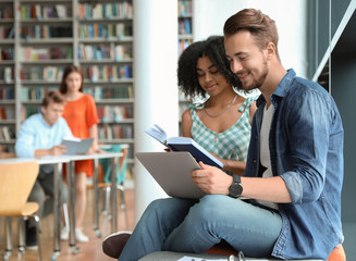 Young people studying together in modern library