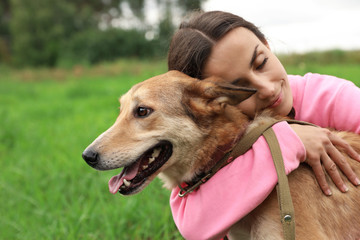 Female volunteer with homeless dog at animal shelter outdoors