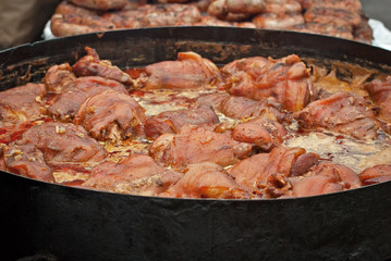 The food is cooked in a large pot on the fire. Field cuisine at the festival.