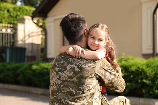 Father In Military Uniform Hugging Little Daughter Outdoors