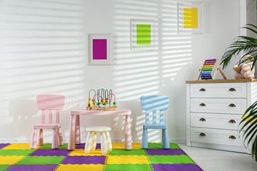 Stylish playroom interior with toys and modern furniture