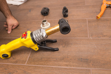 Soldering iron for a plastic water pipe close-up. The device stands heats the temperature.