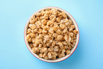 Bowl with healthy granola on light blue background, top view