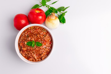 Bolognese (also know as Bolognesa or Bolonhesa) sauce in a white bowl isolated in white background, soft light, studio photo, copy space
