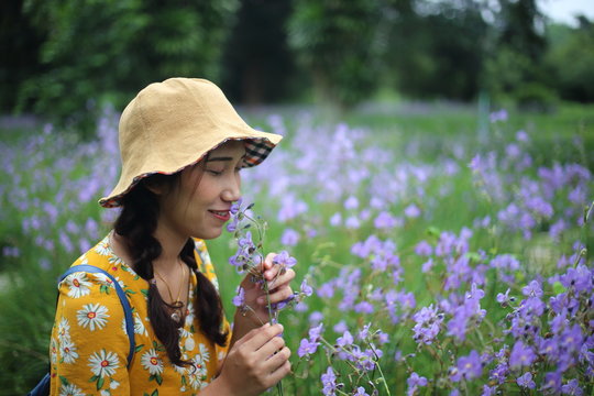 A woman standing appreciated Murdannia giganteum or Sweet purple flowers which crowned at Prachin Buri ,Thailand