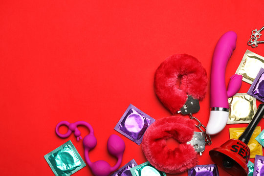 Different sex toys on red background, flat lay. Space for text - Powered by Adobe
