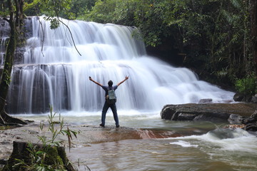 A man standing in Pang Sida waterfall of  Sa Kaeo ,Thailand