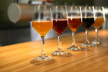 Different sorts of beer on wooden bar counter