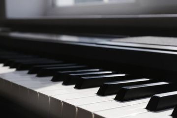 Naklejka premium Modern piano with black and white keys indoors, closeup