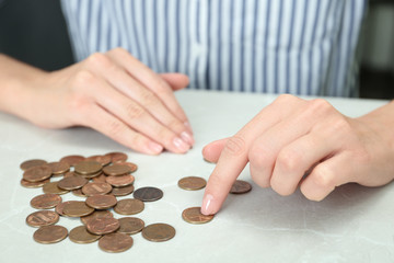 Woman counting coins at light table, closeup