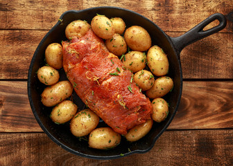 Ready to cook prune, rosemy and garlic stuffed pork fillet with baby potatoes