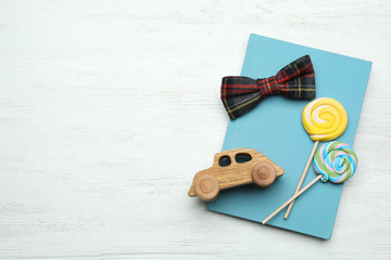 Flat lay composition with man's accessory and candies on white wooden background. Space for text