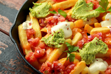 Loaded potato nachos with melted cheddar cheese, sour cream, tomato salsa, chilli, guacamole and beer