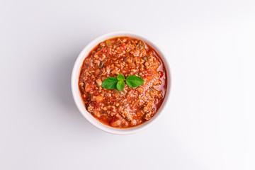 Bolognese (also know as Bolognesa or Bolonhesa) sauce in a white bowl isolated in white background, soft light, studio photo, copy space